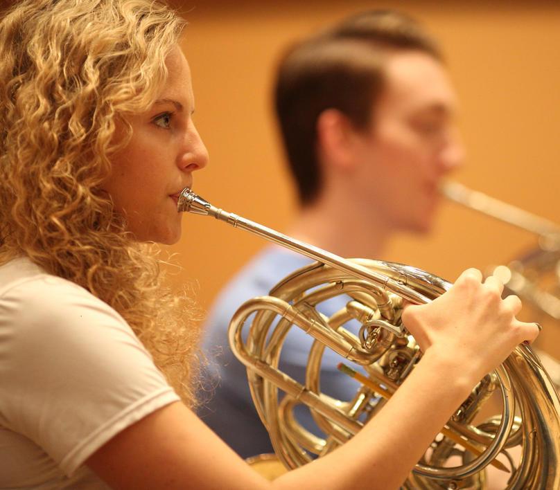 French 角 player in an orchestra rehearsal