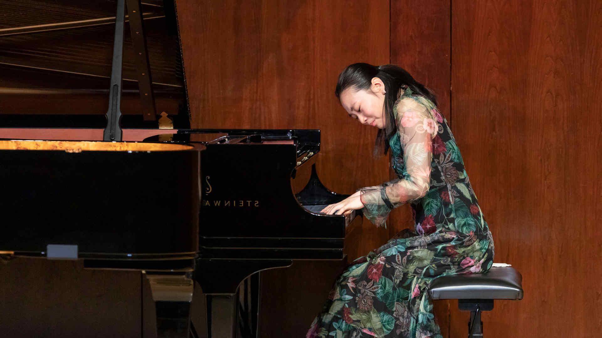 A pianist in the midst of performance making an expressive face